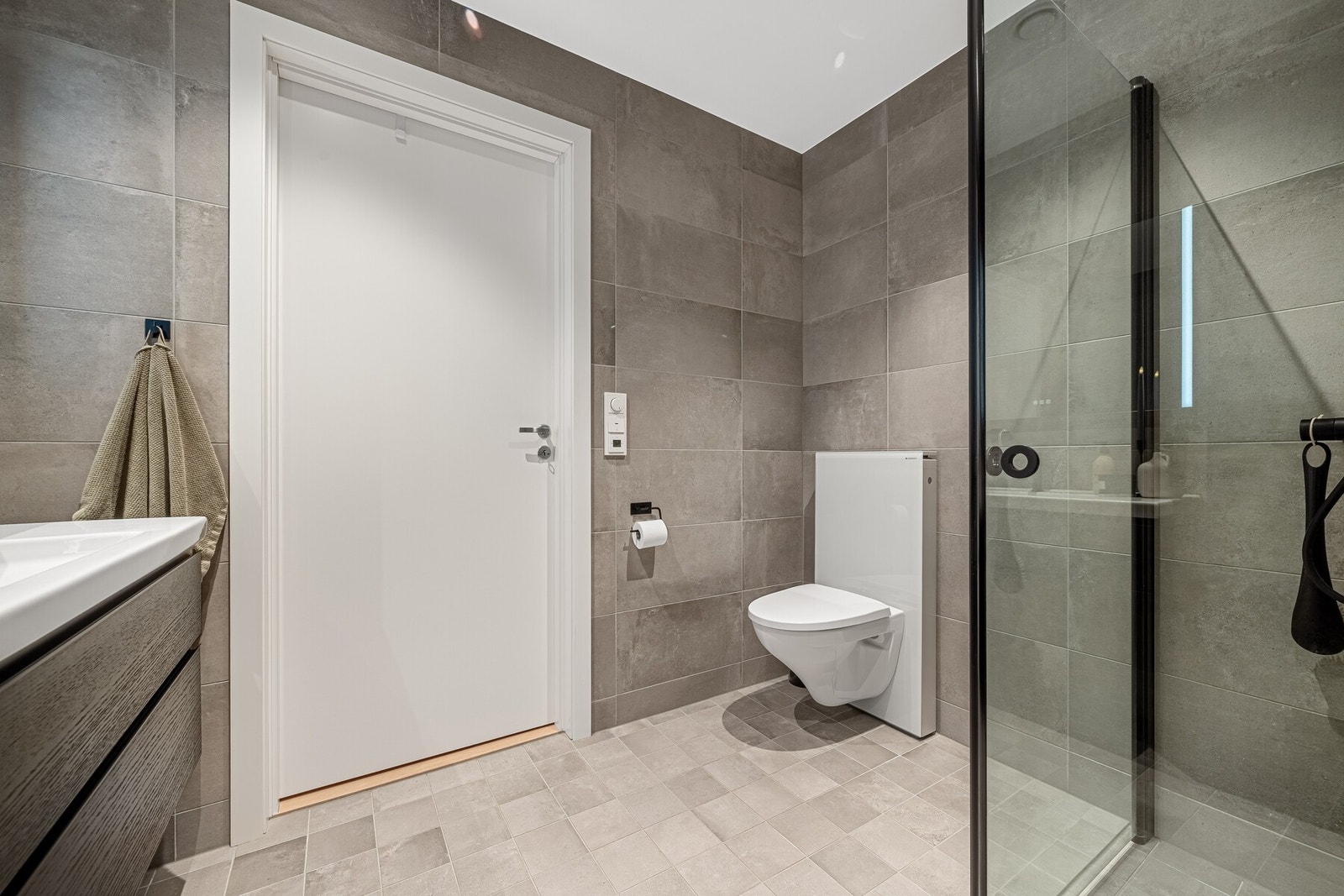 Badet er innredet med dusjhjørne, toalett, og servant. Det er også et vaskerom i 1.etg. Der er det også montert toalett slik at det er 2 toaletter i boligen. Galleribilde