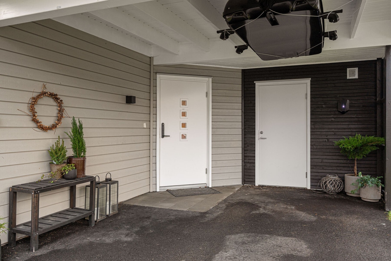I carporten finner man inngangspartiet og inngang til uteboden. Det er i tillegg montert elbil-lader. Galleribilde