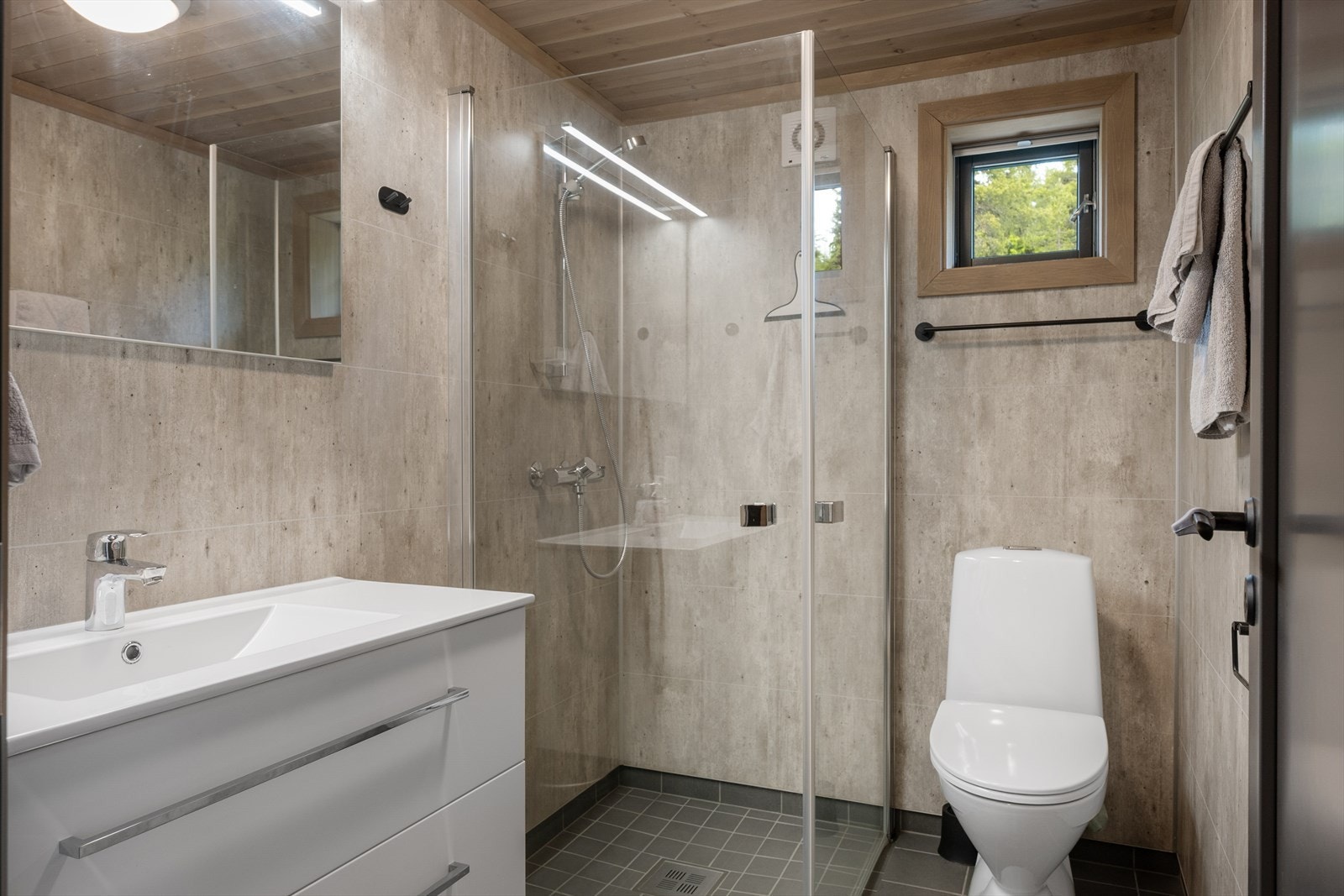 Interiøret er likt i begge bad og består av lys innredning, innfellbare dusjvegger og gulvmontert wc. Galleribilde