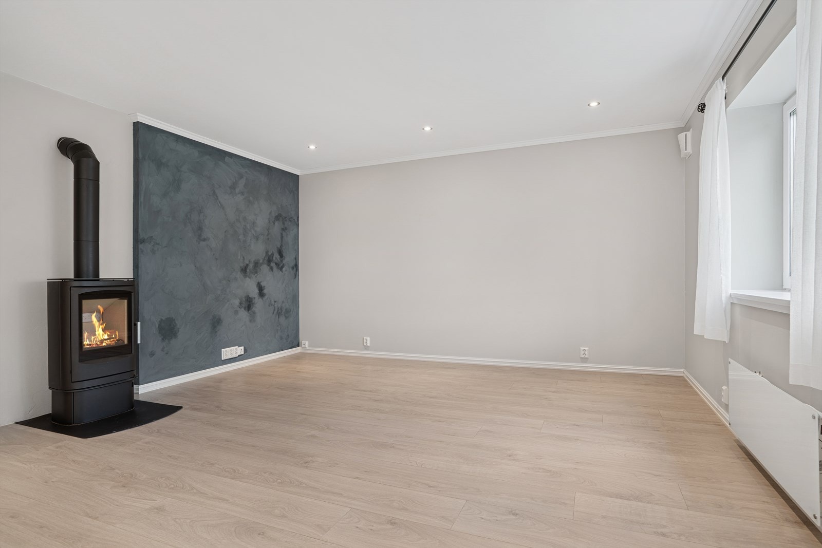 Elegant stue med kontrastvegg og peis - et naturlig samlingspunkt i hjemmet. Galleribilde