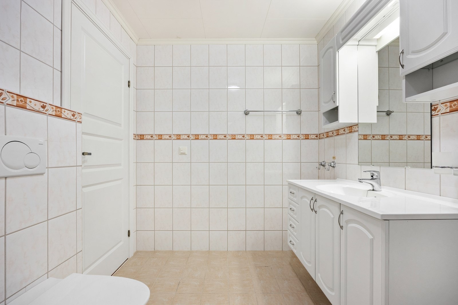 Innredningen har heldekkende servant over skapmøblement, matchende vegg- og høyskap og i overkant speil med belysning. Galleribilde