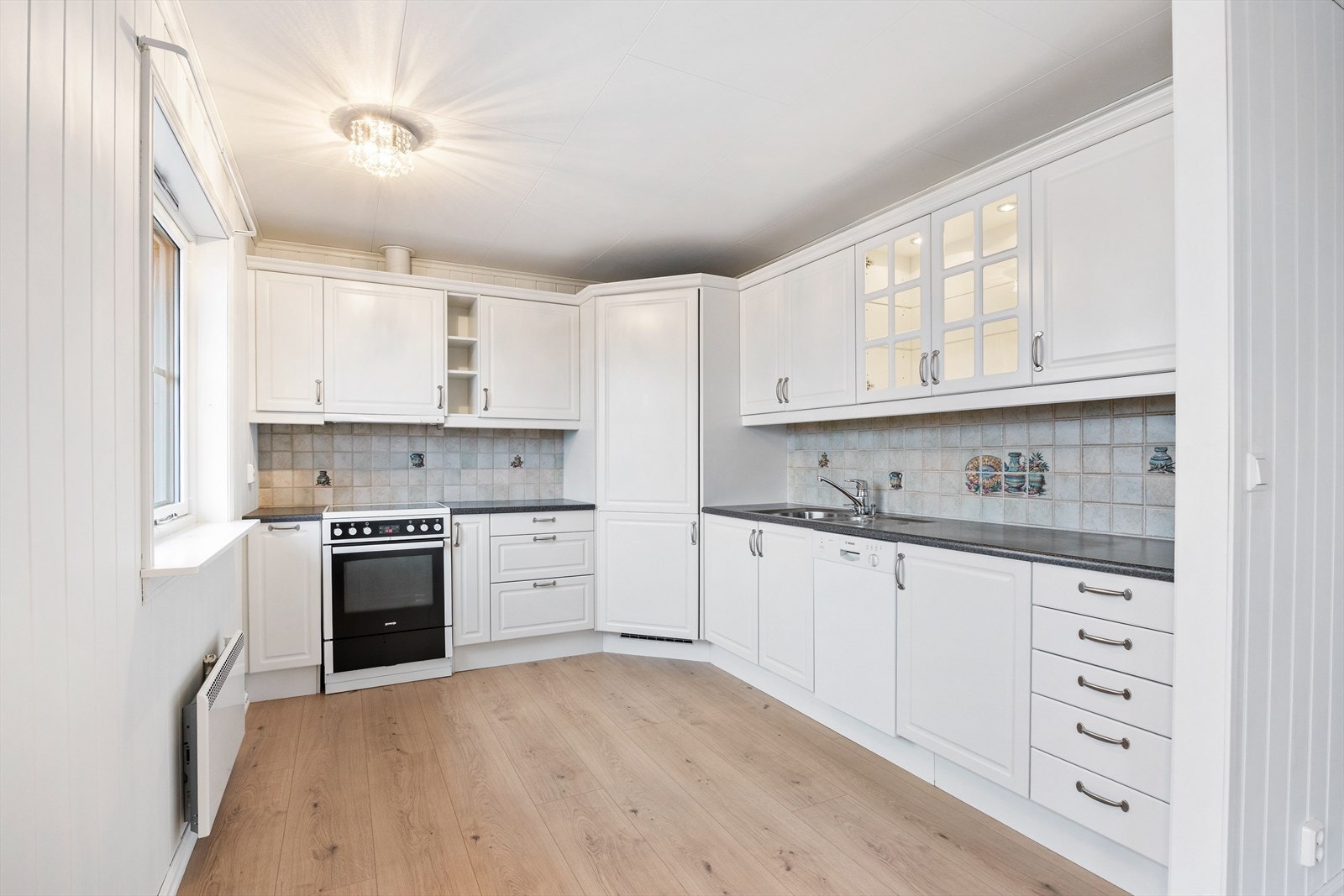 Kjøkkenet har en tidløs og klassisk stil med innredning i en praktisk, arbeidseffektiv vinkelløsning - med integrert kjølehjørne. Galleribilde