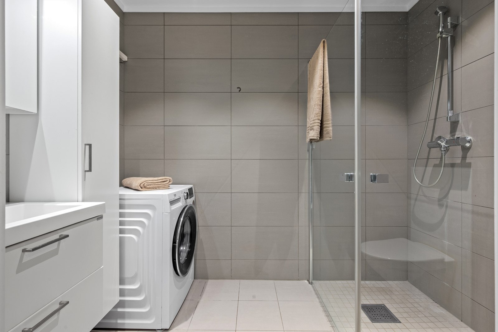 Badet har flislagt vegger og gulv, og god plass for vaskemaskin og tørketrommel. Galleribilde