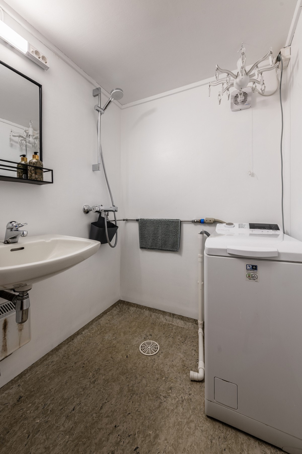 Badet har vinylbelegg på gulv og våtromstapet på vegg, og har servant og dusj, samt opplegg for vaskemaskin. Galleribilde