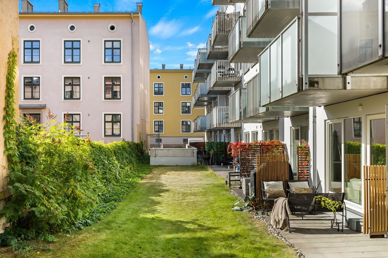 Den ligger åpent ut mot en velholdt, felles gressplen som gir en rolig og trivelig uteopplevelse. Galleribilde