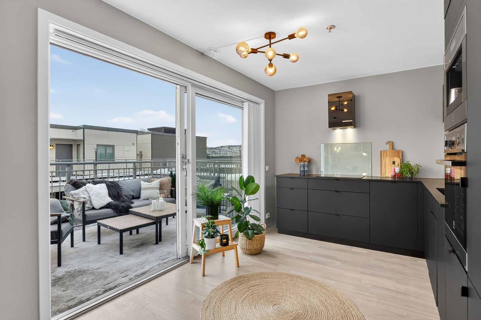 Romslig kjøkken med skyvedør ut til en solrik balkong Galleribilde