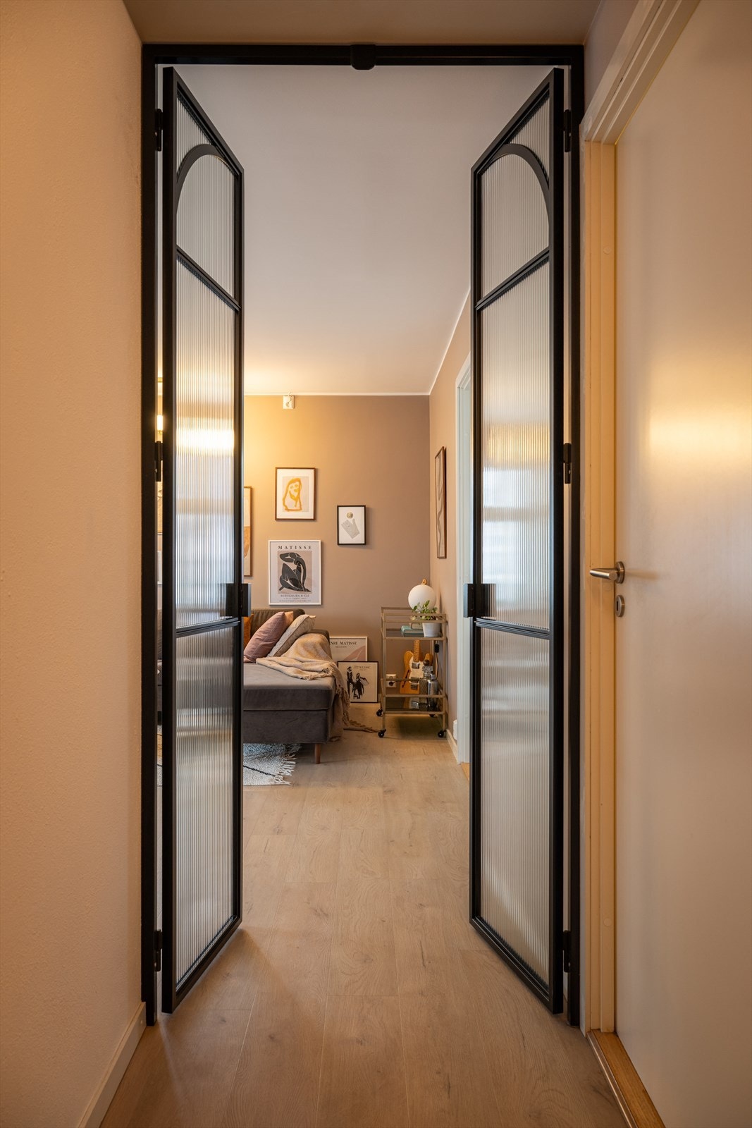 Fra entréen er det flotte spesiallagde smijernsdører inn til stuen/kjøkken. Døren er laget og levert av Dominius AS. Galleribilde