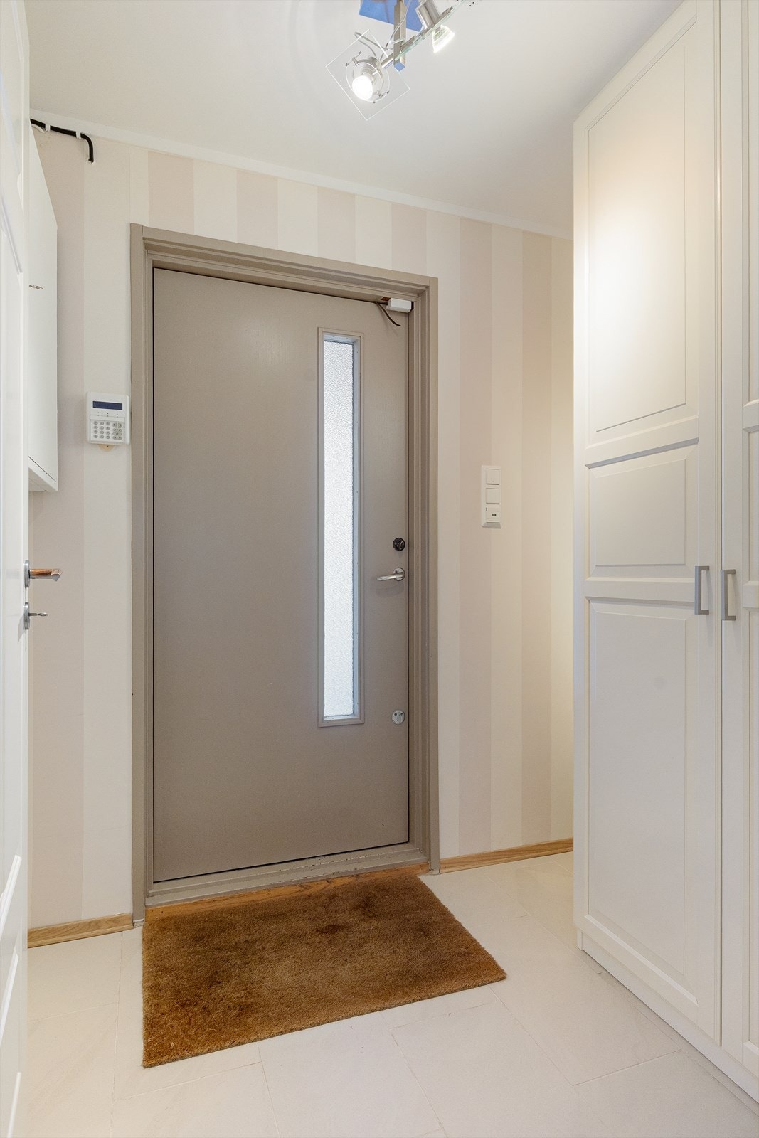 Romslig entré med flislagt gulv og varmekabler. Galleribilde