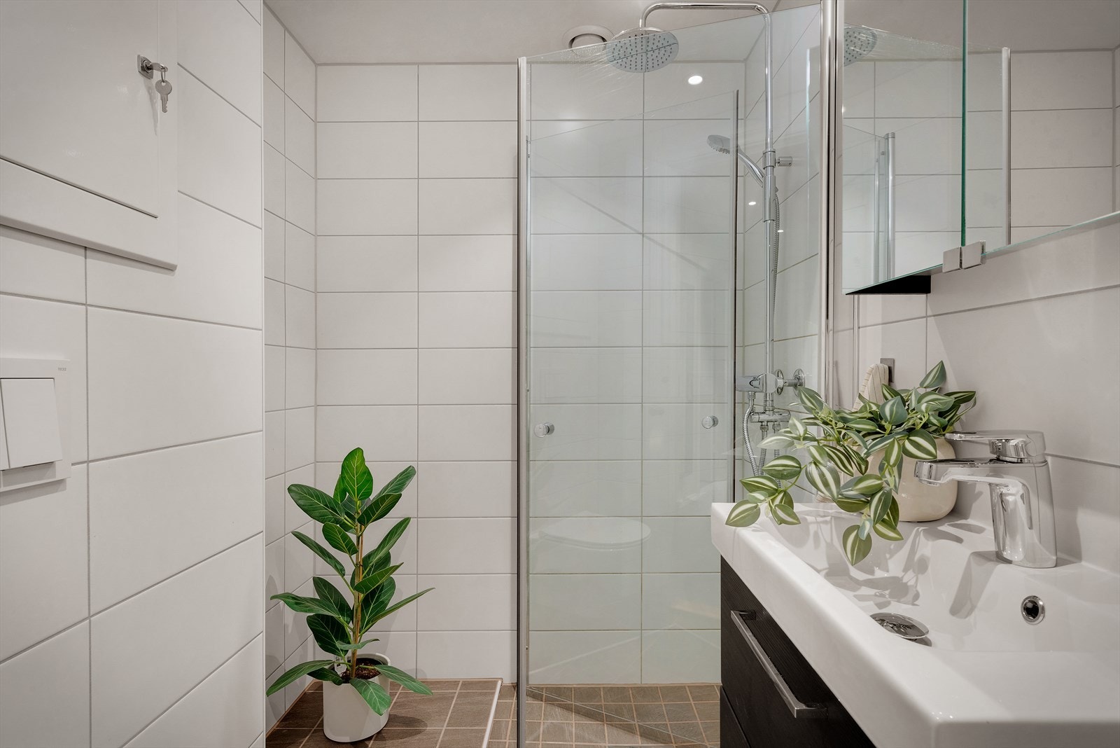 - Badet inneholder servant med møblement, speilskap og belysning, vegghengt toalett og innfelbart dusjhjørne i glass - Galleribilde