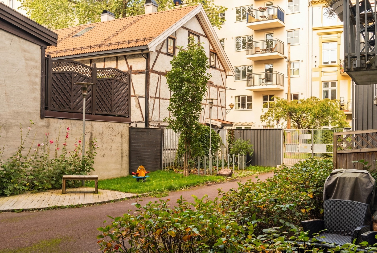 Utenfor boligen møter du et frodig og grønt utsyn i sommerhalvåret, hvor sameiet er kjent for godt vedlikeholdte og velstelte fellesarealer Galleribilde