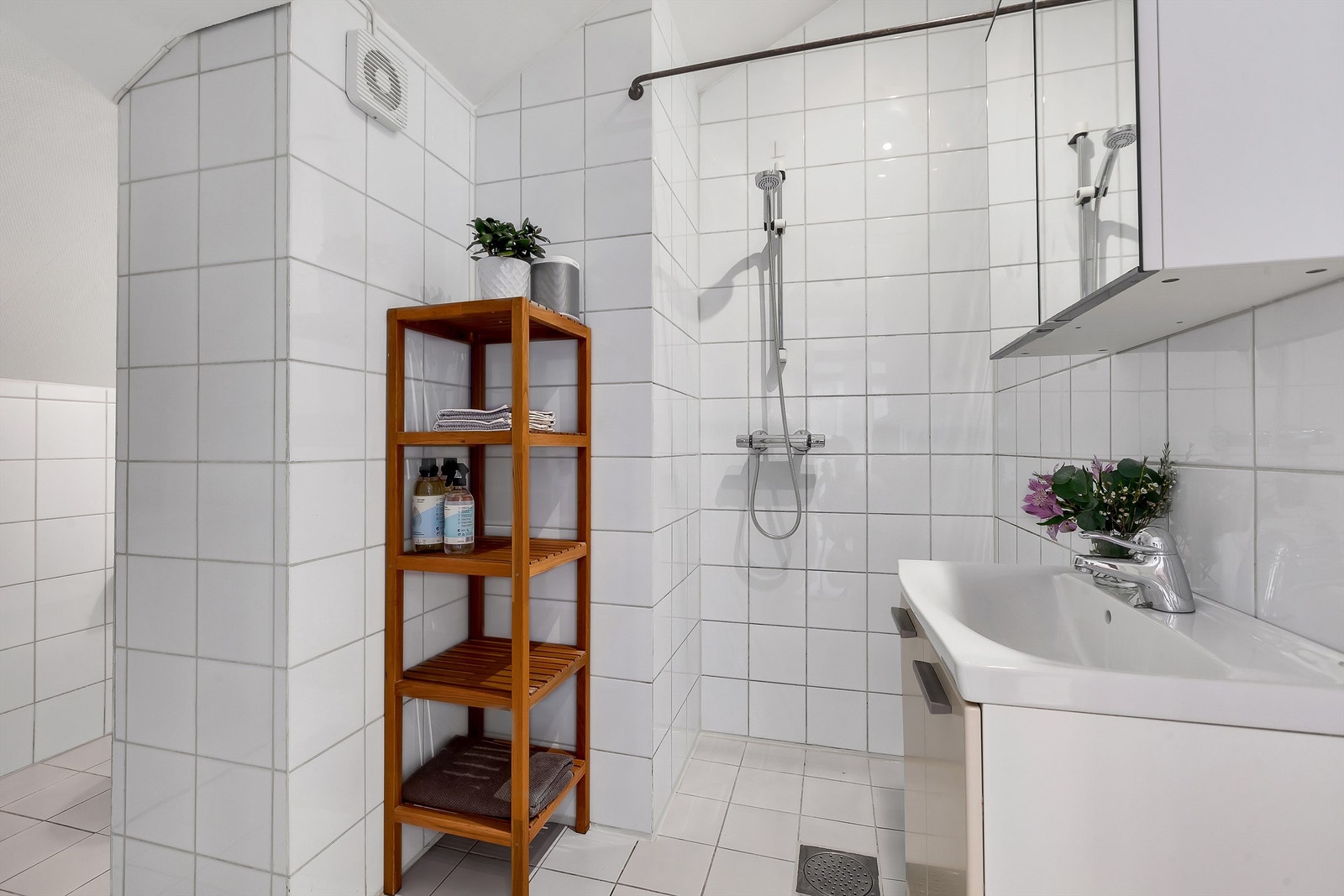 Romslig og flislagt baderom - bra med lagringsplass i baderomsinnredningen og vaskemaskin. Galleribilde