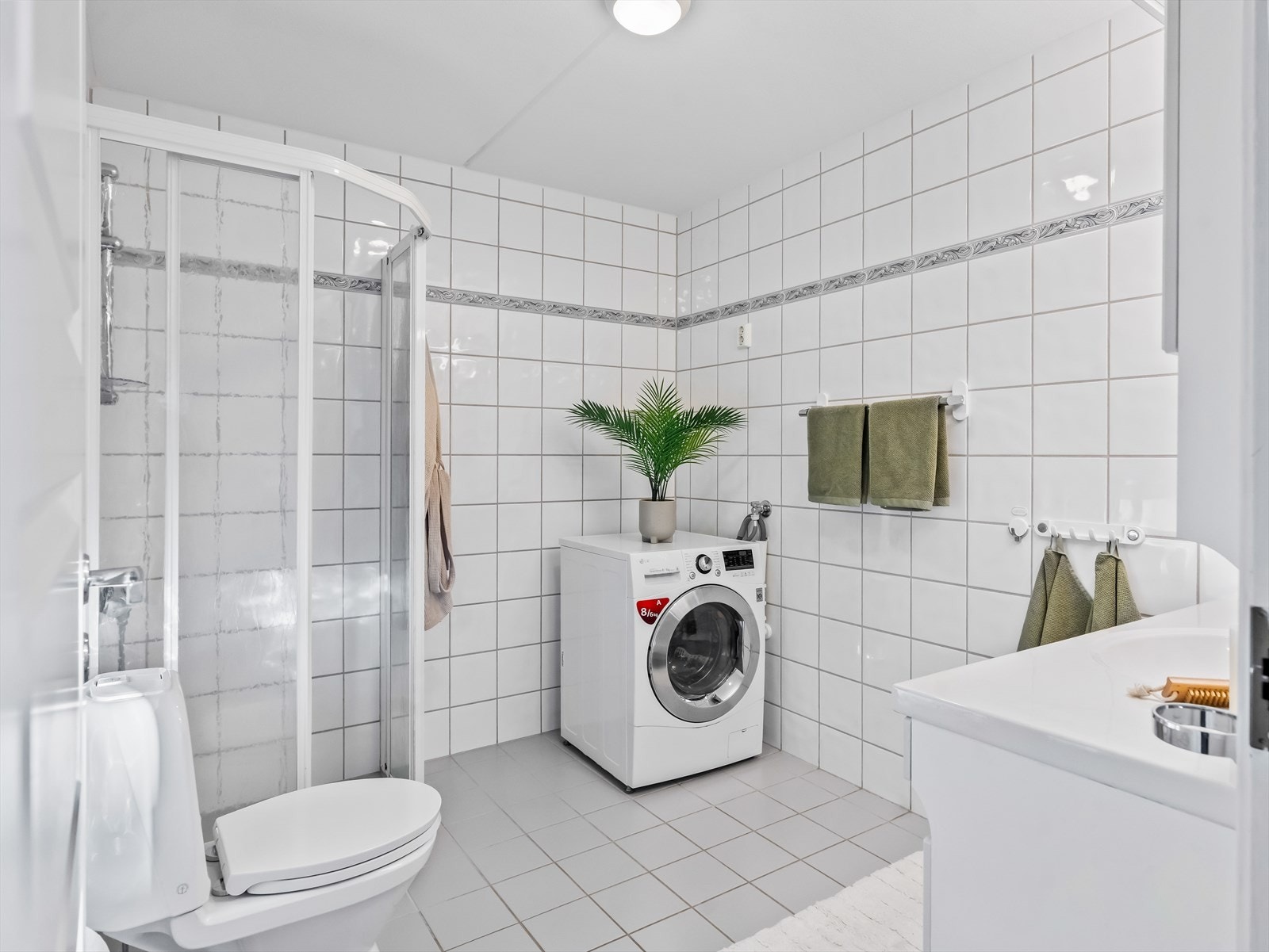 Rommet har opplegg for vaskemaskin, gulvmontert toalett og dusjhjørne med skyvedører, håndholdt dusj og termostatstyrt blandebatteri. Galleribilde