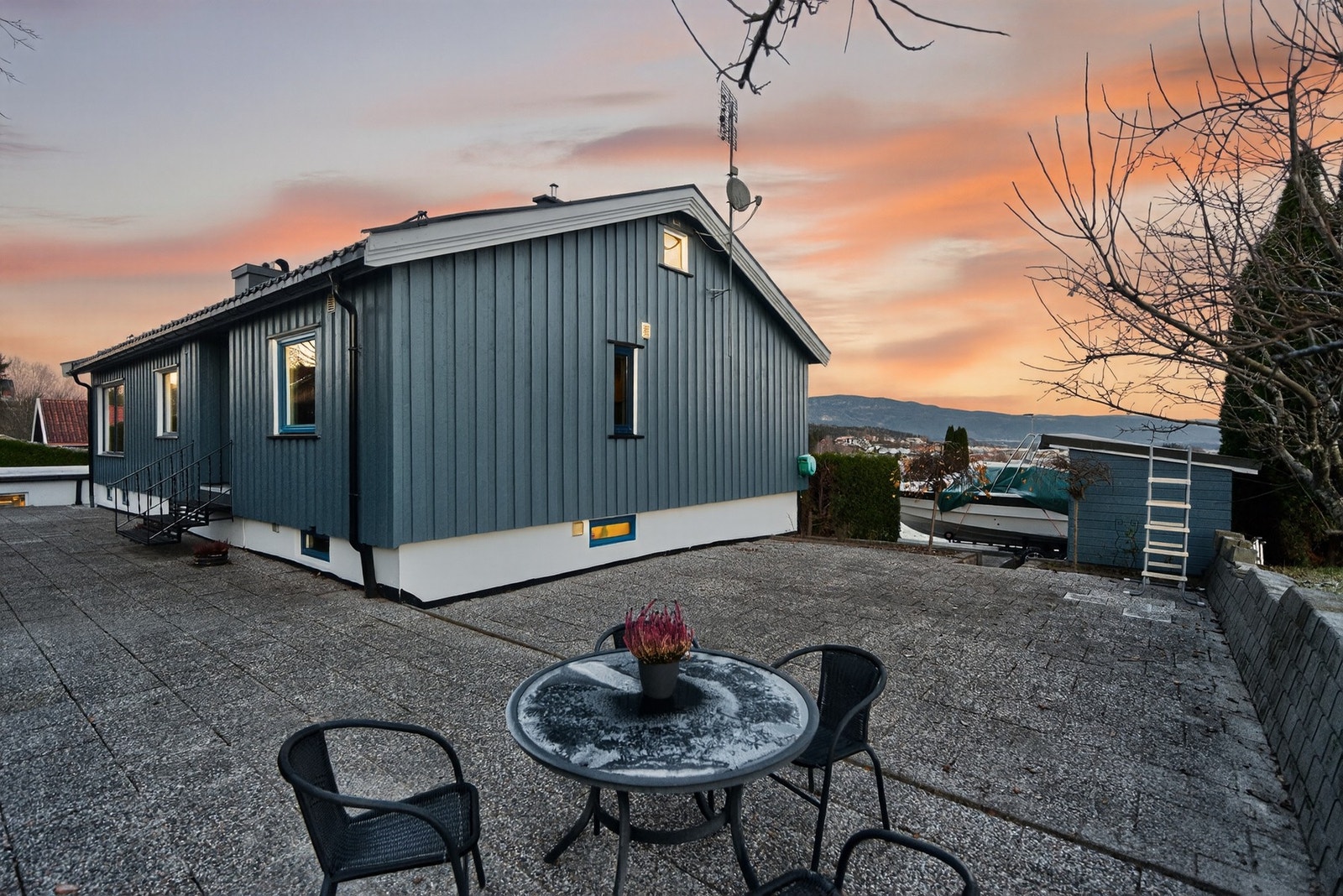 Steinbelagt uteområde, med tilhørende sittegruppe. Galleribilde