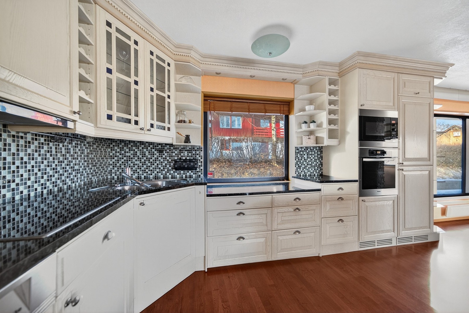 Moderne og velutstyrt kjøkken. Integrerte hvitevarer. Lyse fronter og mørke benkeplater. Galleribilde