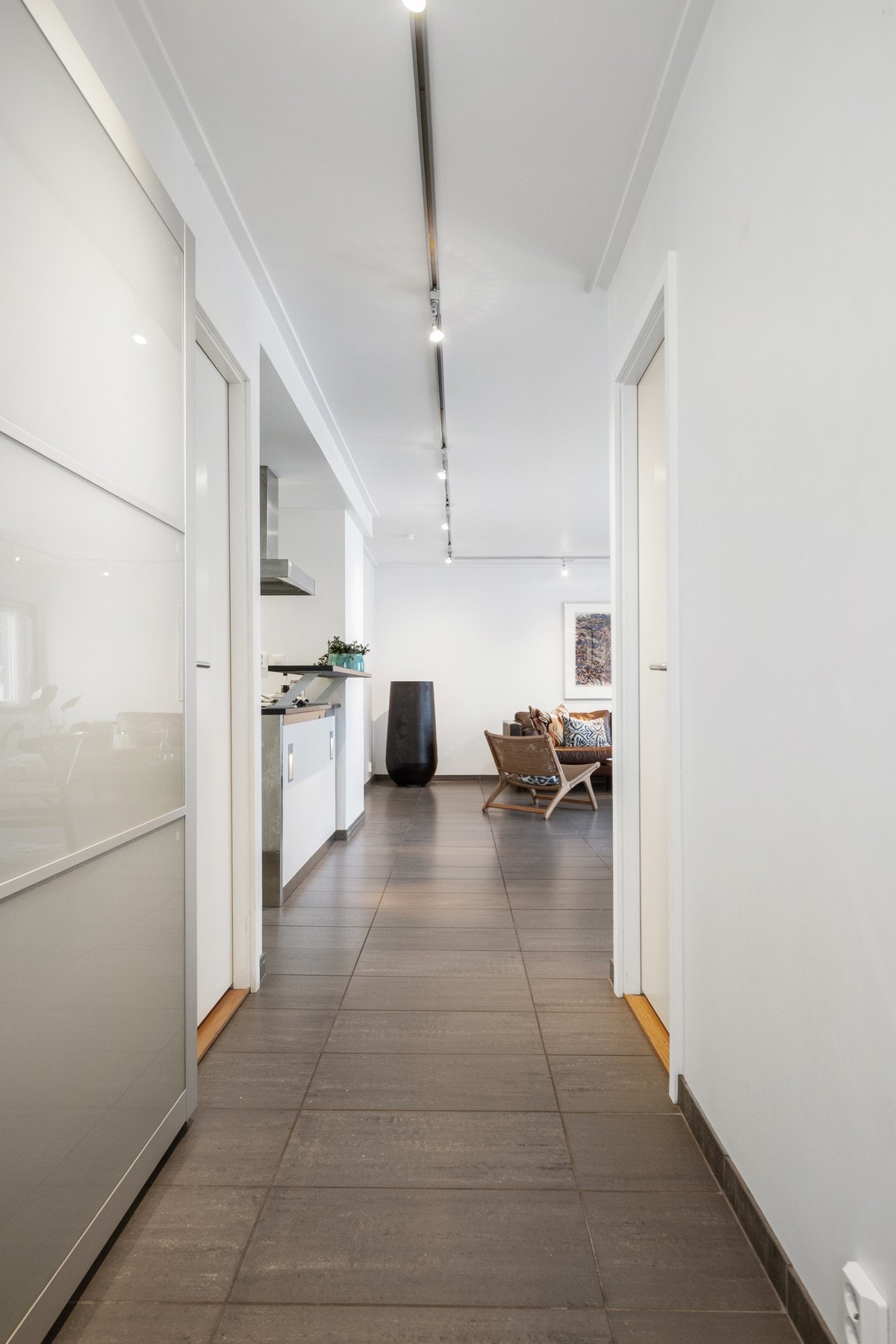 Entreen har direkte adkomst til stuen, og gulvet er belagt med grå fliser med varmekabler. Galleribilde