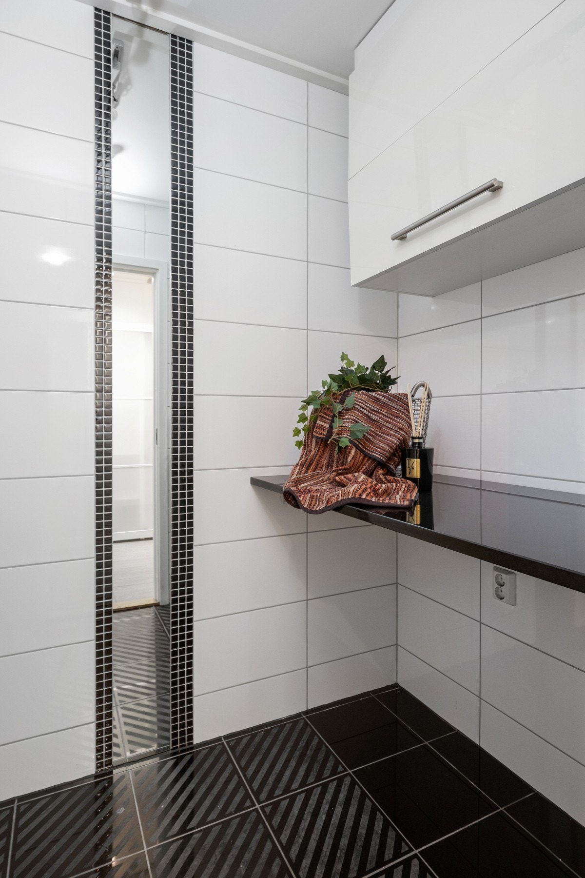 Vaskerommet er helfliset og har gulvvarme, skyllekum i stål og arbeidsbenk med overskap. Under benken er det opplegg for vaskemaskin. Galleribilde