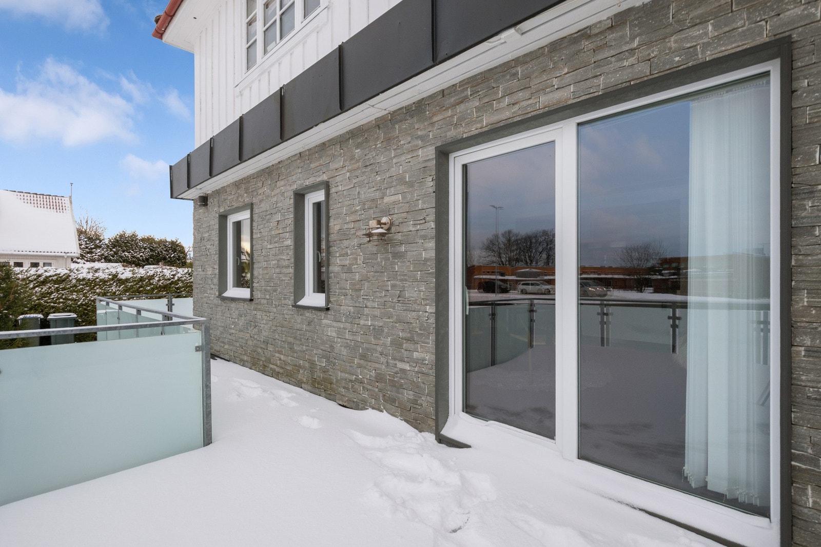 Uteplassen er utstyrt med belysning, har glassrekkverk og trapp ned til fellesarealet. Galleribilde