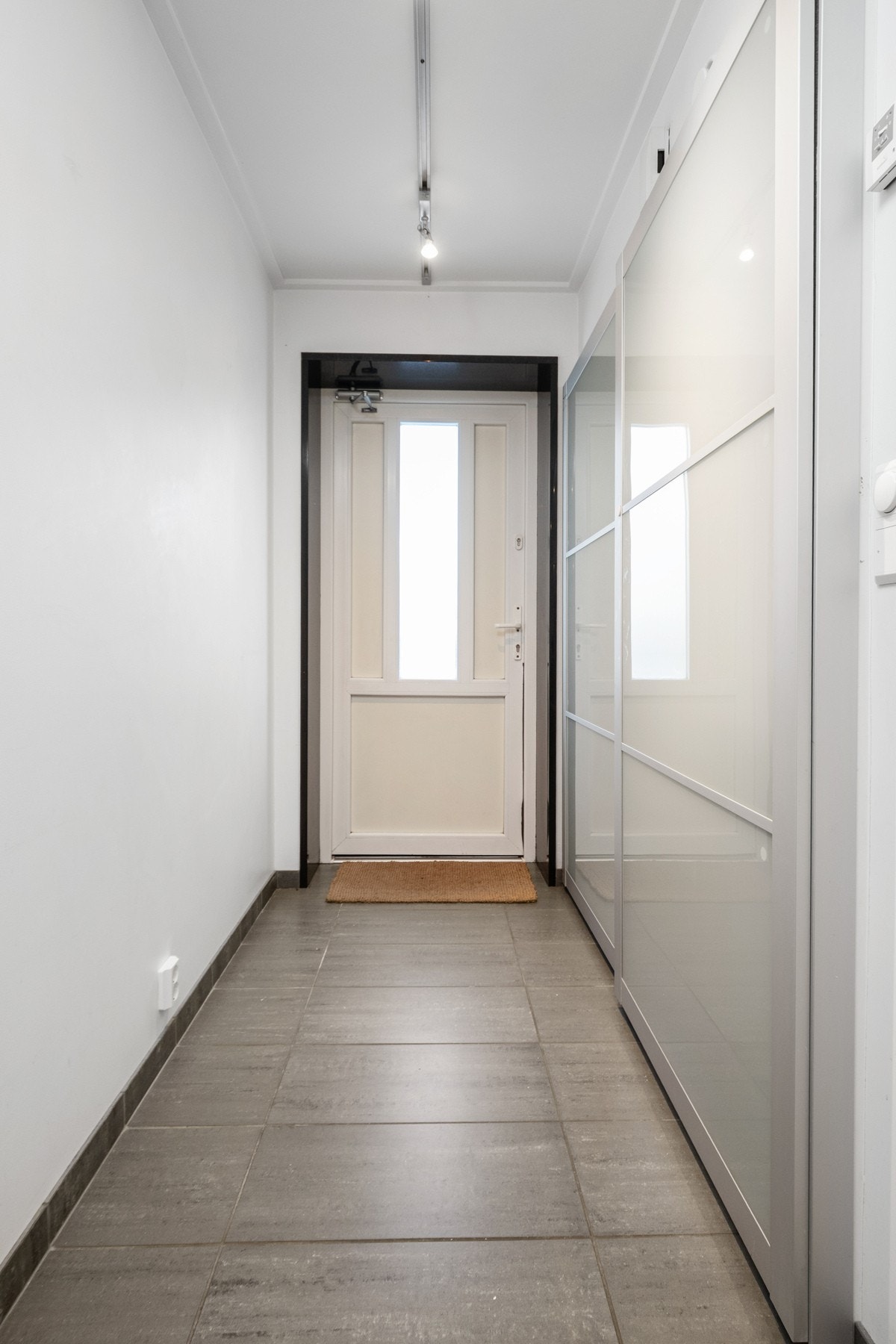 Veggene er malt i hvitt, og det er god oppbevaringsplass i en stor skyvedørsgarderobe. Galleribilde