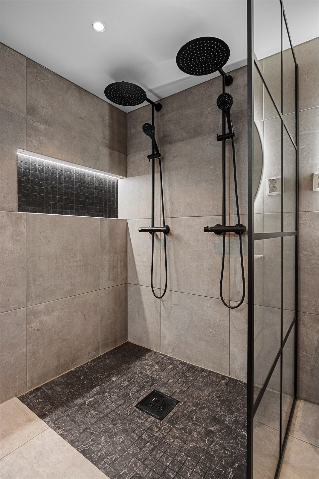 Dette må sies å være et av de mest fantastiske rommene i hele boligen med dobbel dusj, badekar, lekre fliser og innredning. Galleribilde