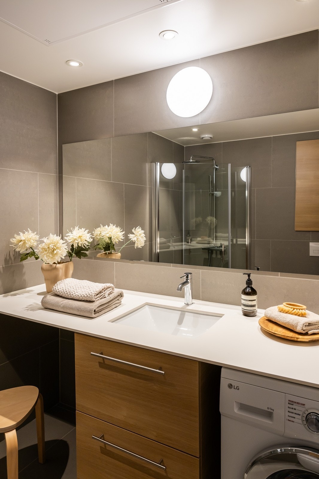 Helfliset baderom med varme i gulv, regnfallsdusj, vegghengt toalett og medfølgende vaskemaskin Galleribilde