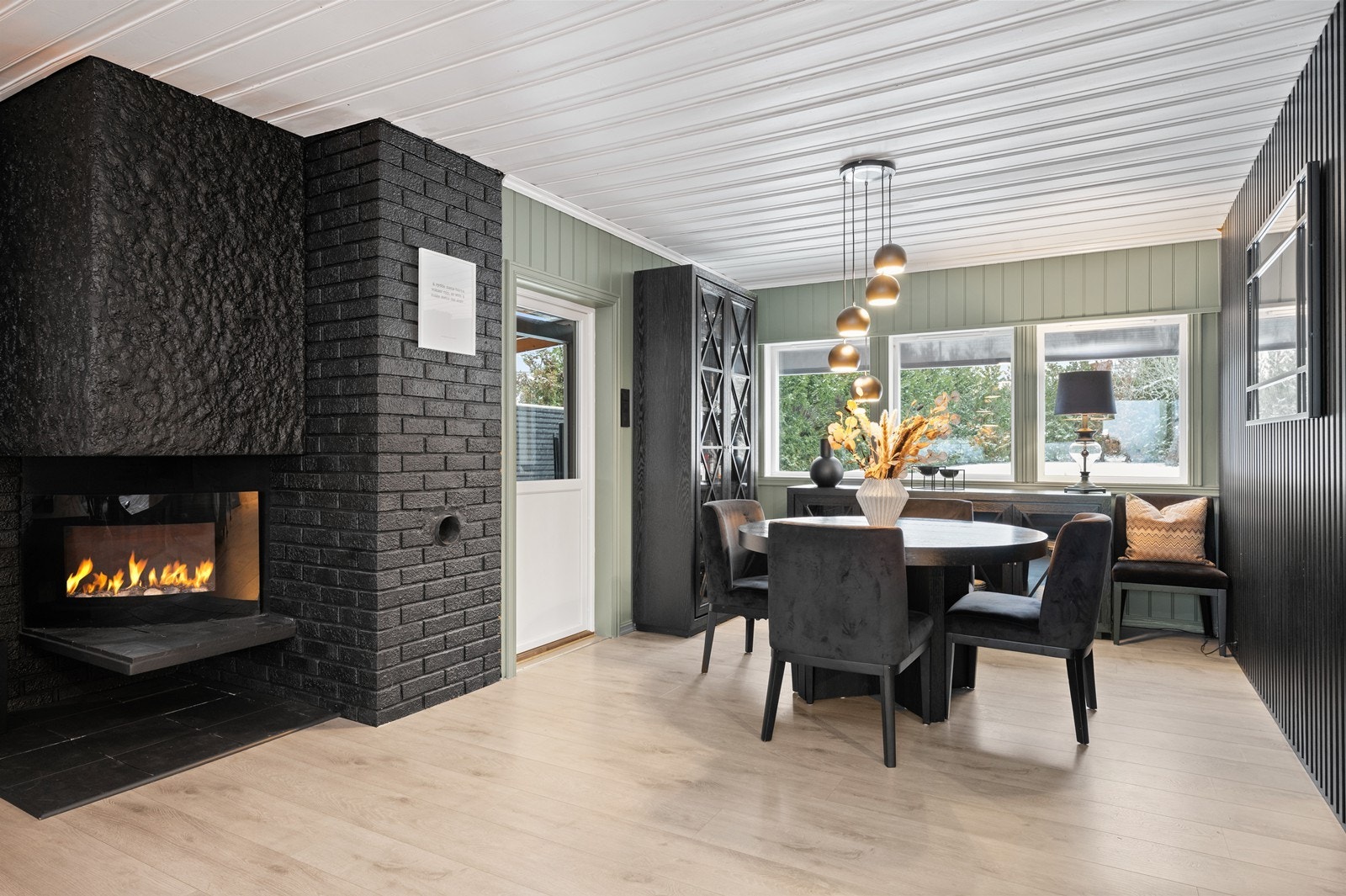 En spilevegg og gjennomgående laminatgulv skaper en helhetlig stil i oppholdsrommene Galleribilde