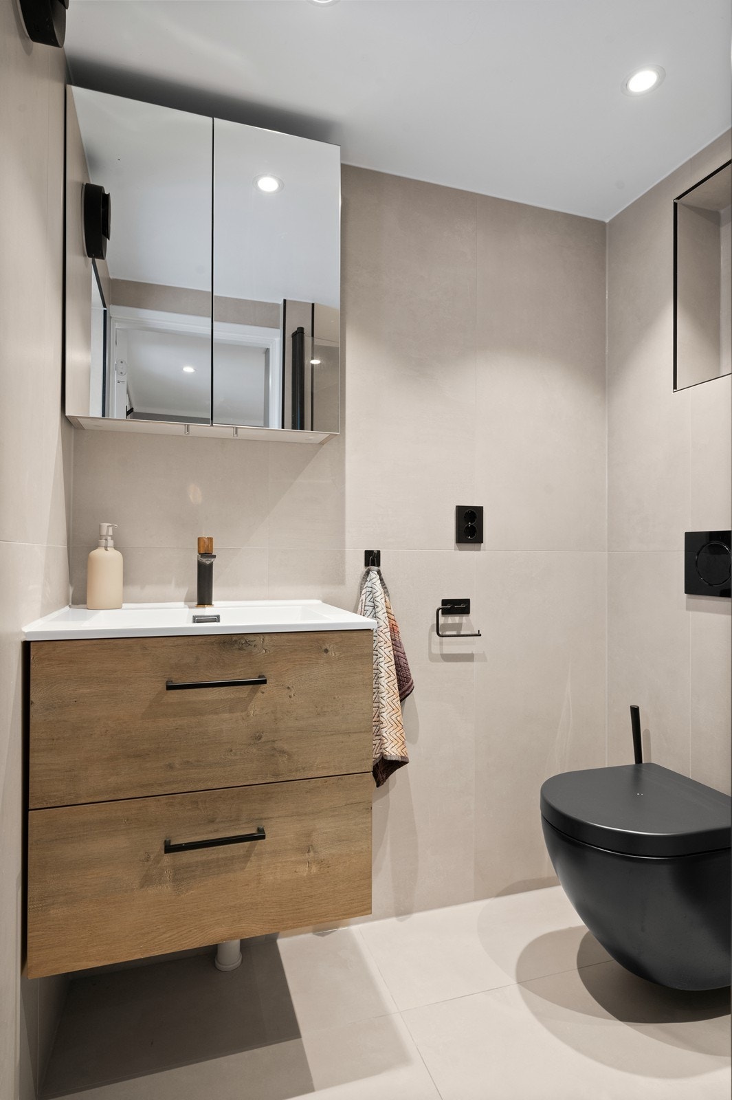 Badet i kjelleren er fra 2023, med flislagte overflater og vegghengt toalett. Galleribilde