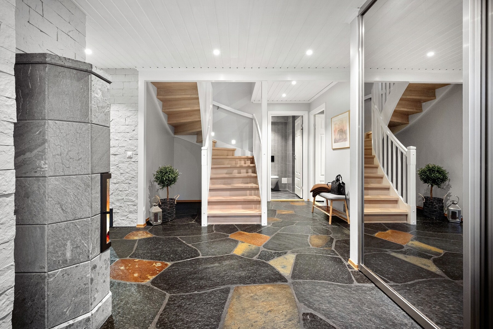 Inngangsdøren leder inn til en romslig hall med flislagt gulv og praktiske garderobeløsninger. Galleribilde