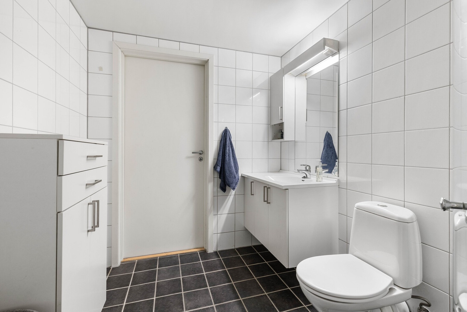 . Her er det også opplegg for vaskemaskin. Badet fremstår funksjonelt og lettstelt, med praktiske overflater. Galleribilde