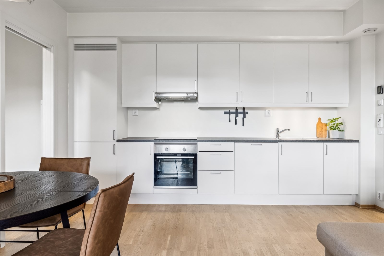 Leiligheten har en åpen stue- og kjøkkenløsning som forener stue og kjøkken til et sammenhengende og sosialt rom Galleribilde