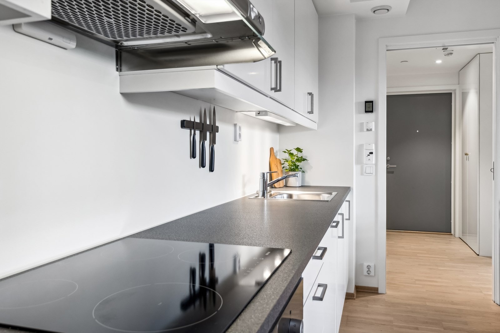 Kjøkkeninnredningen består av hvite, glatte skapfronter som komplementeres av en fin mørk benkeplate i laminat. Her har man gode oppbevaringsmuligheter i romslige skap, samt godt med benkeplass. Galleribilde