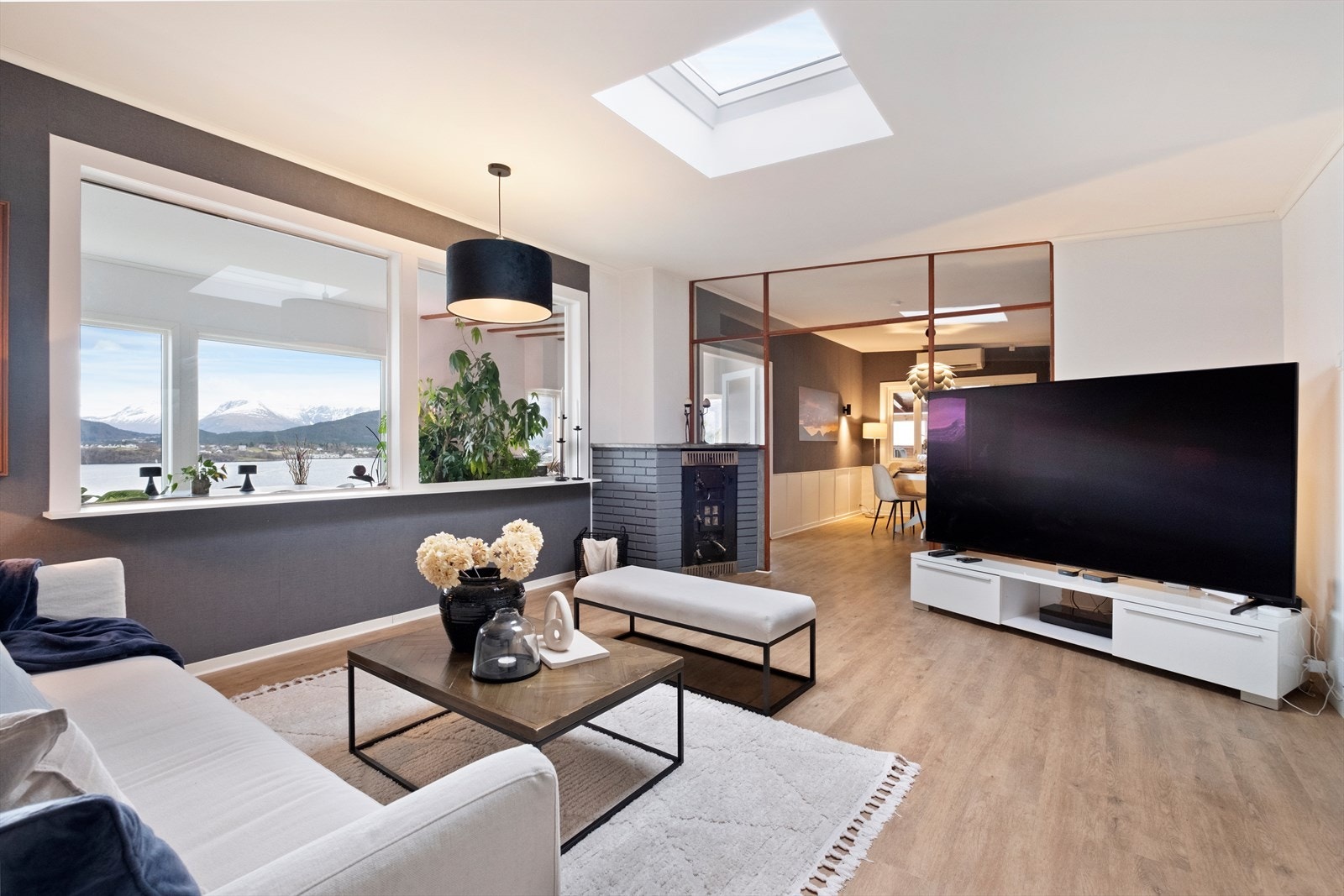 Lys og innbydende stue med lyskuppel og vinduer mot fremre del som gir utsikt og god dybde i rommet. Galleribilde