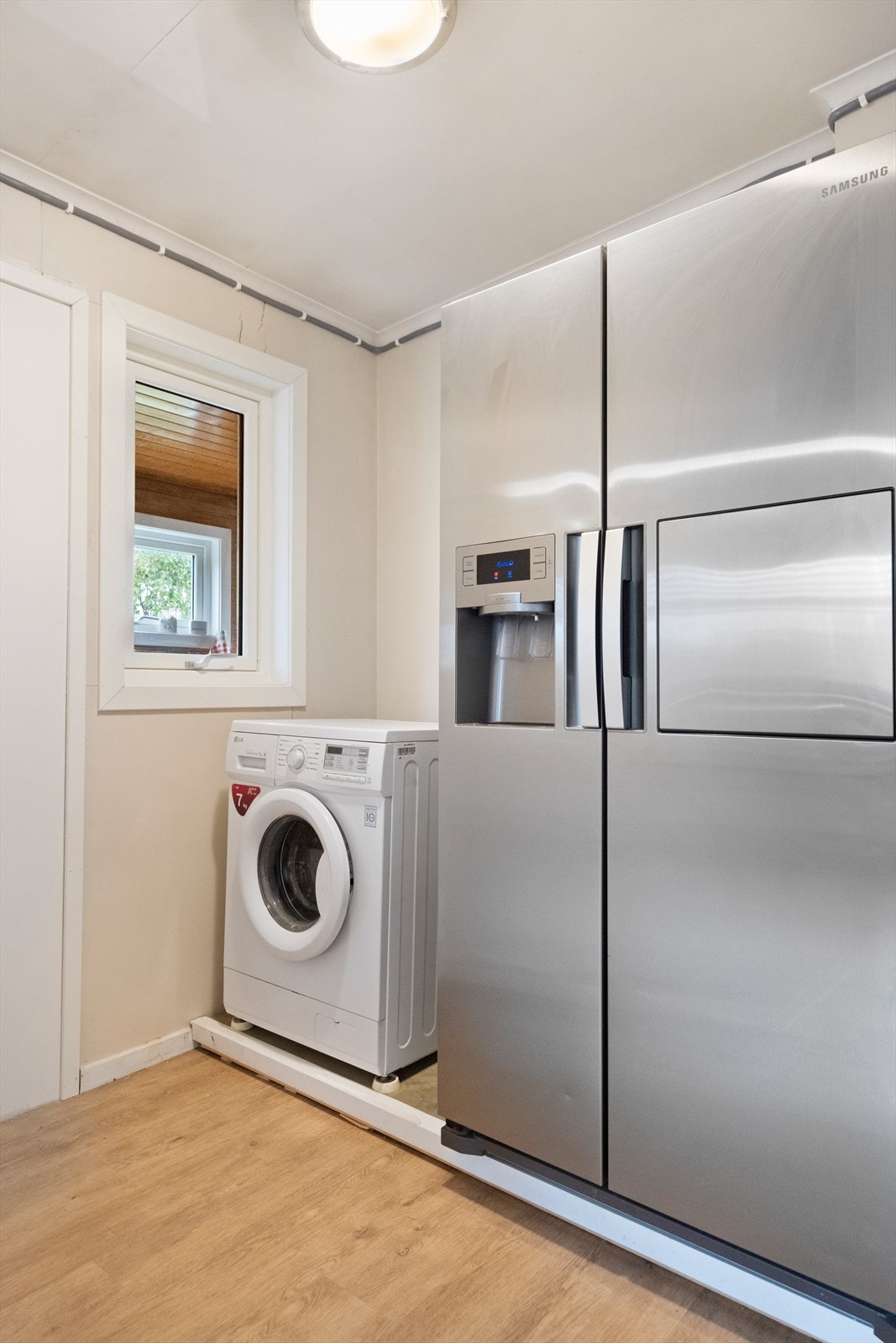 Det er en vaskeromsdel på kjøkkenet med enkelt opplegg for vaskemaskin. Galleribilde