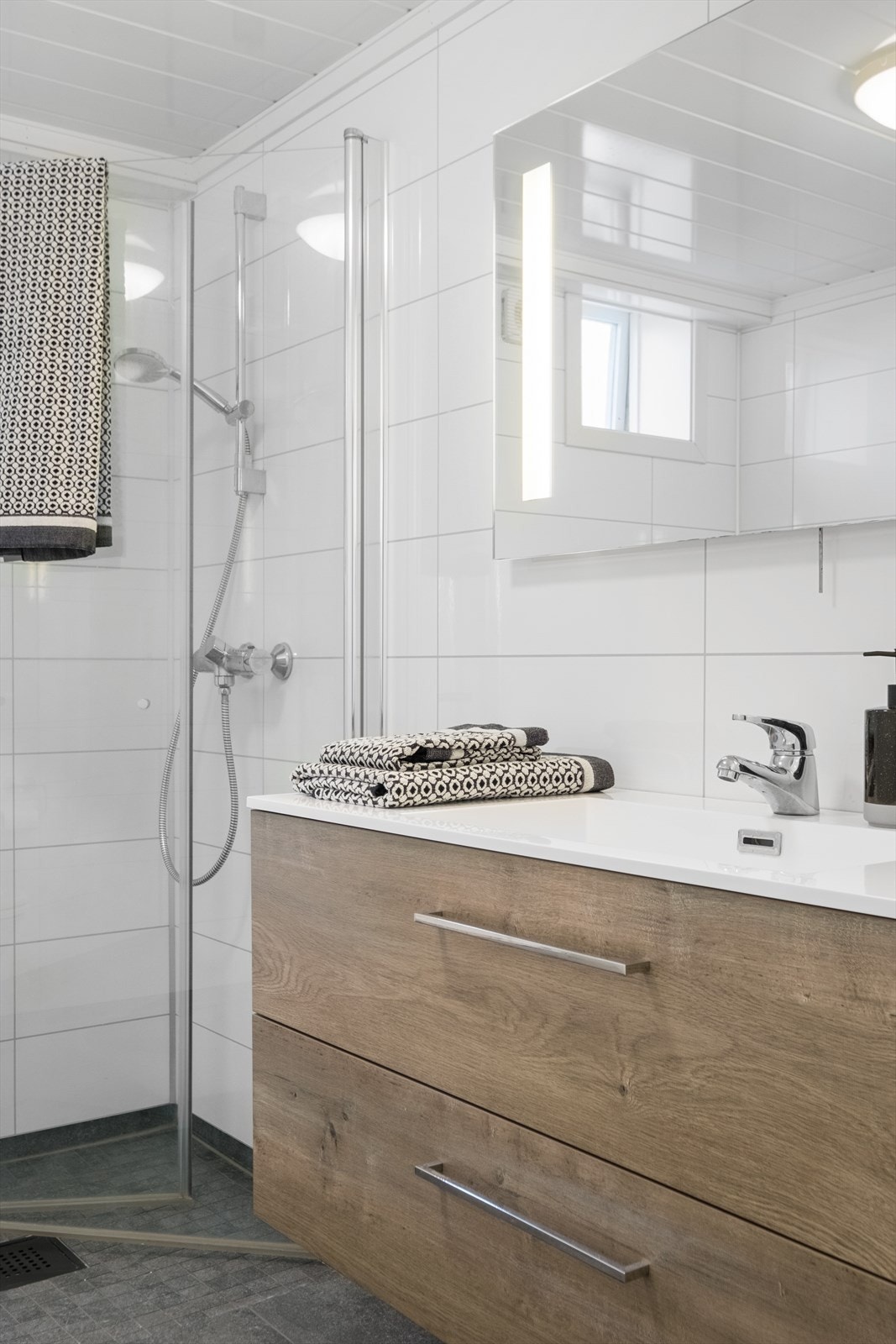 Baderommet har lekkert servantskap med nedfelt servant og speil over. Frittstående toalett. Dusjnisje med glassvegger. Galleribilde