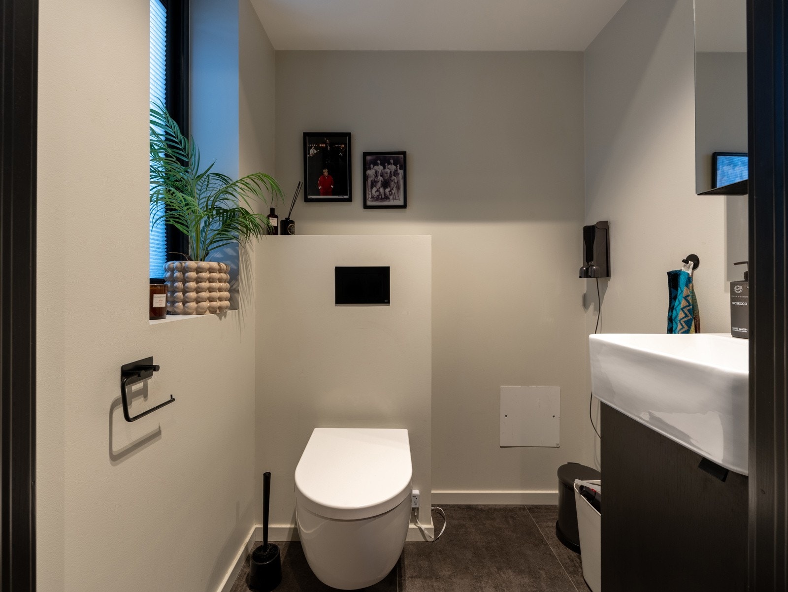 Toalettrom i inngangspartiet i 1.etasje med flislagt gulv. Veggmontert wc og servant og skap.