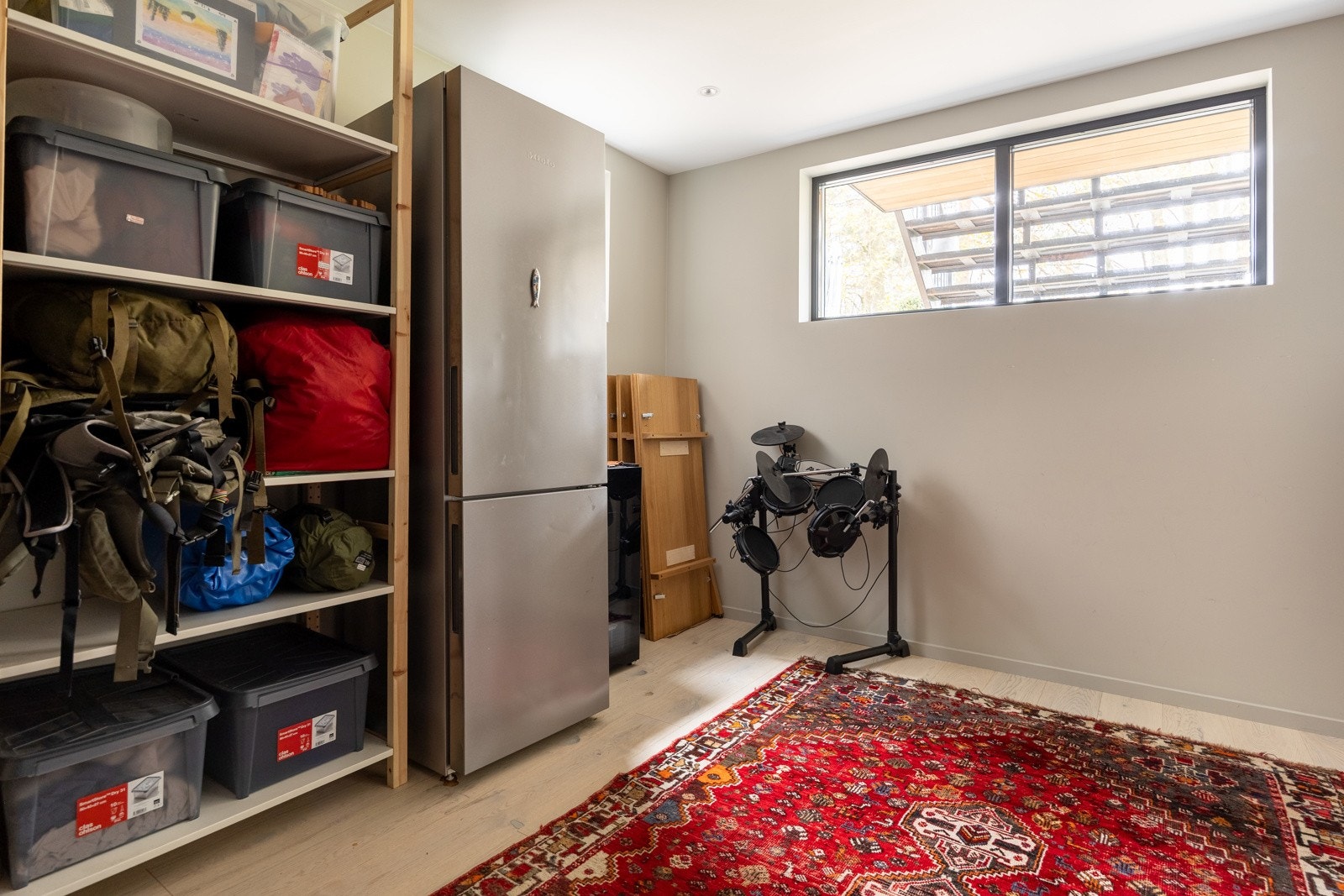 Et stort rom med vinduer mot to himmelretninger, mål til 10,8 kvm. Rommet er byggemeldt som bod.