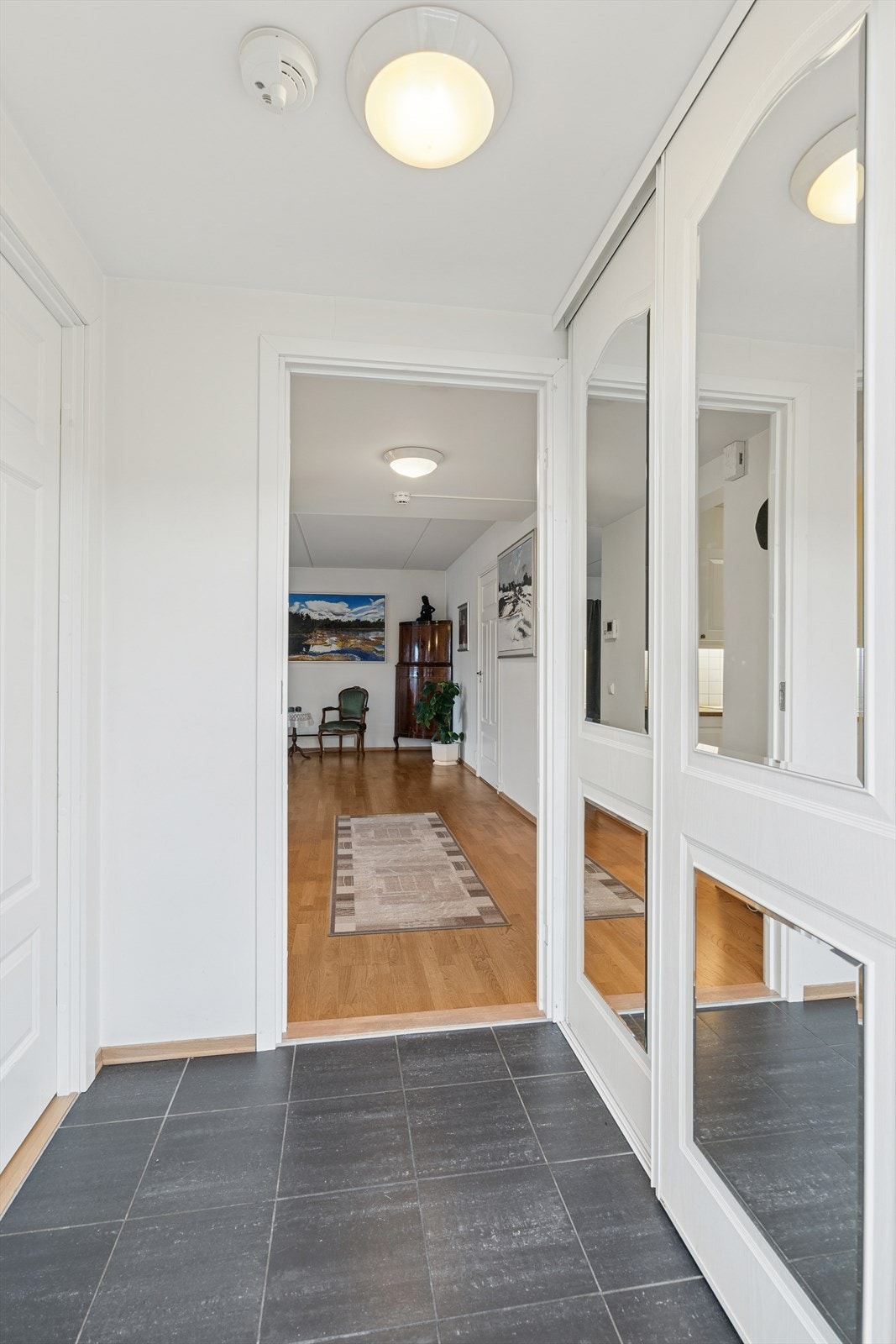 Her ønskes du velkommen inn i en flislagt entré med god plass til å oppbevare ytterklær og sko i skyvedørsgarderobe. Galleribilde