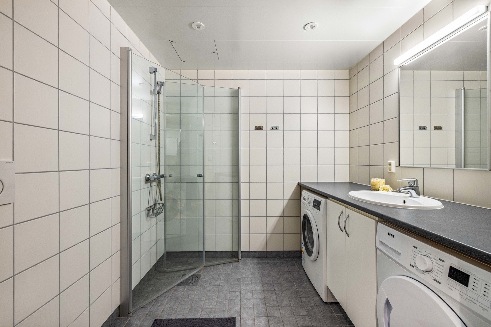 Flislagt baderom med varme i gulvet og downlightsbelysning. Galleribilde