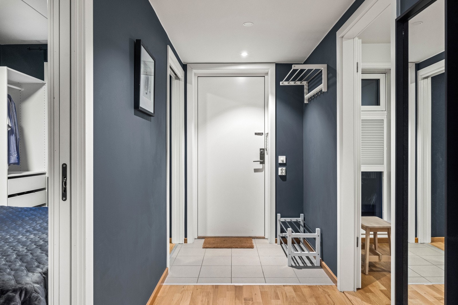 Entréen har gode muligheter for å henge fra seg ytterjakken og sette fra seg skoene før man går videre inn. Flislagt parti ved døren. Galleribilde