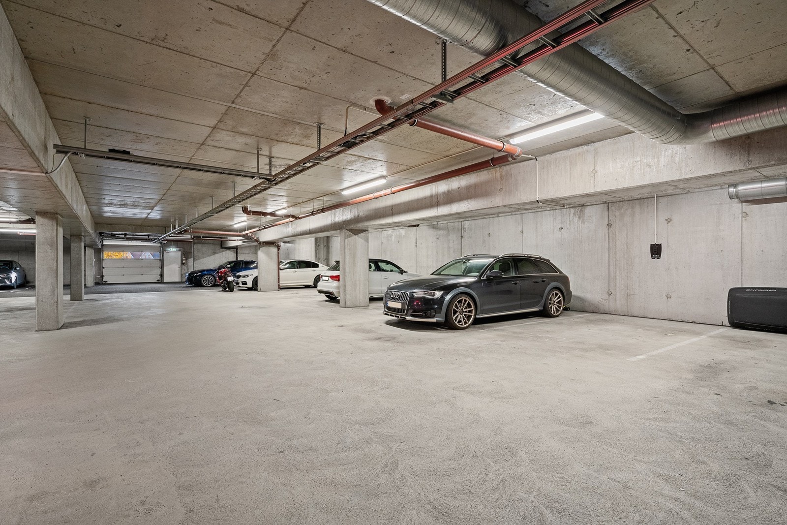 Fast parkeringsplass i lukket garasjeanlegg, med mulighet for elbil-lader. Det er etablert ladepunkt, men selve ladeboksen mangler. Galleribilde