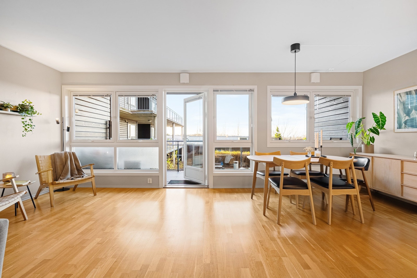 Store vindusflater gjør rommet ekstra åpent og romslig, samtidig som den ligger delvis skjult mot kjøkken av en halvvegg. Galleribilde