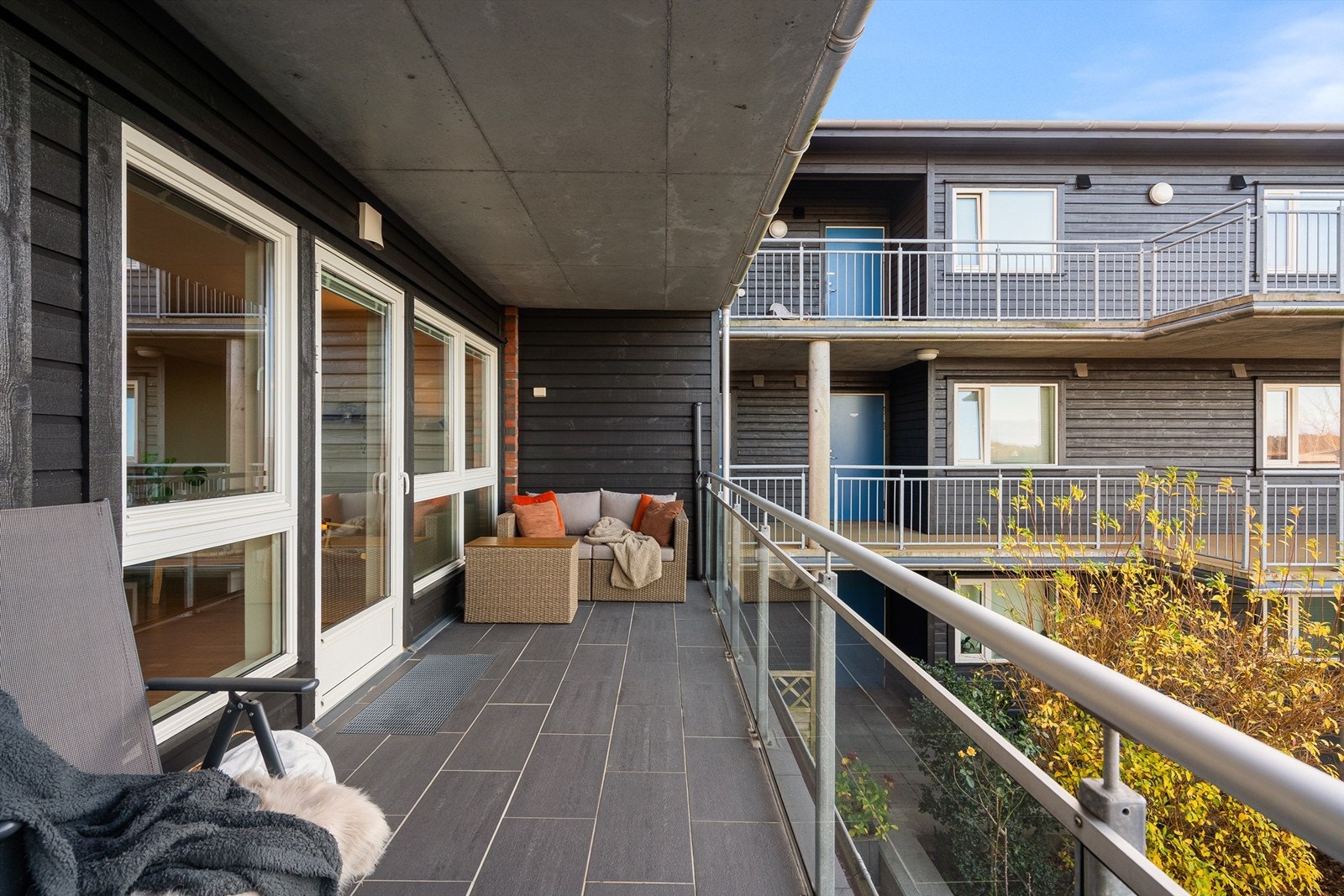 Romslig, overbygd balkong, med god plass til hagemøbler. Her kan man nyte solen utover dagen. Galleribilde