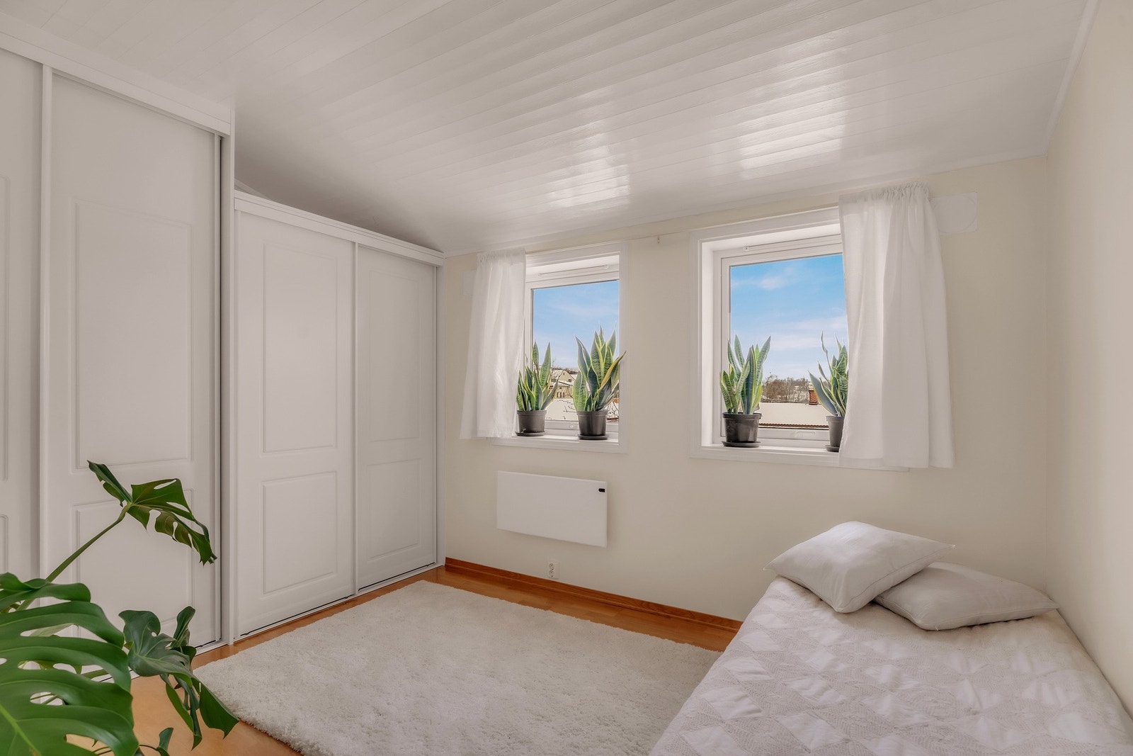 Romslig soverom med to vinduer og smart skyvedørsgarderobe Galleribilde