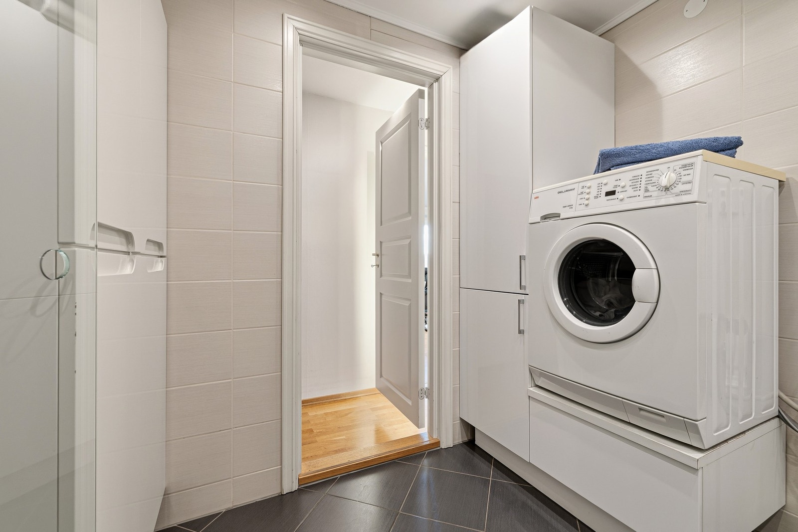 Badet har også høyskap og opplegg for vaskemaskin med en praktisk skuffeanordning Galleribilde