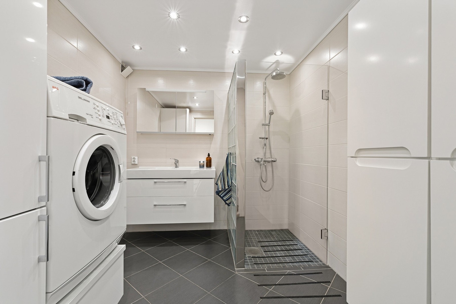 Sentralt i leiligheten ligger et stort og godt bad fra 2012 med servant og dusjplass Galleribilde