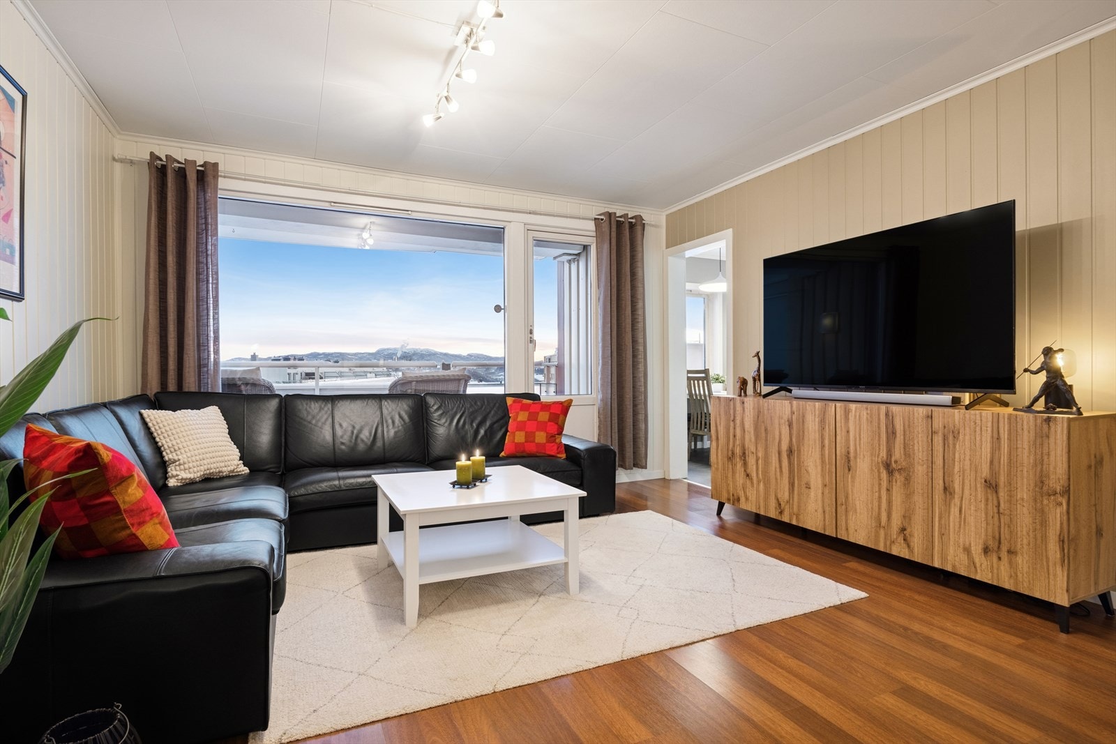 Store vinduer gir godt med naturlig lys og utsikt til balkongen fra stuen. Galleribilde