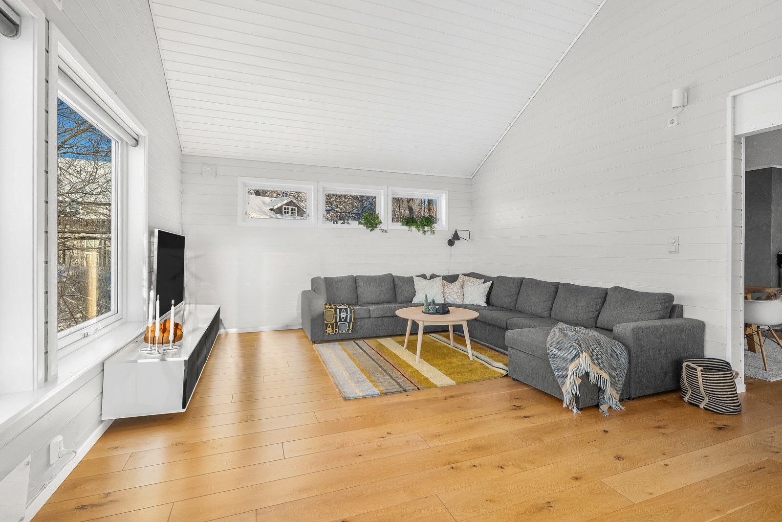 Overflater i lyse toner og oppvarming via panelovner fra 2017 og peisovn fra 2018. Galleribilde