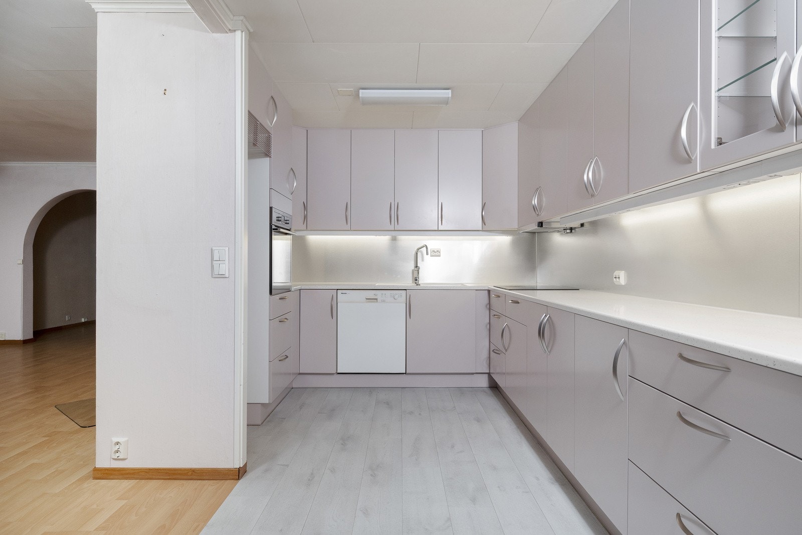 Pent kjøkken med innredning fra Fossline med integrert ovn, nisje for kjøleskap og oppvaskmaskin som følger med i salget. Galleribilde