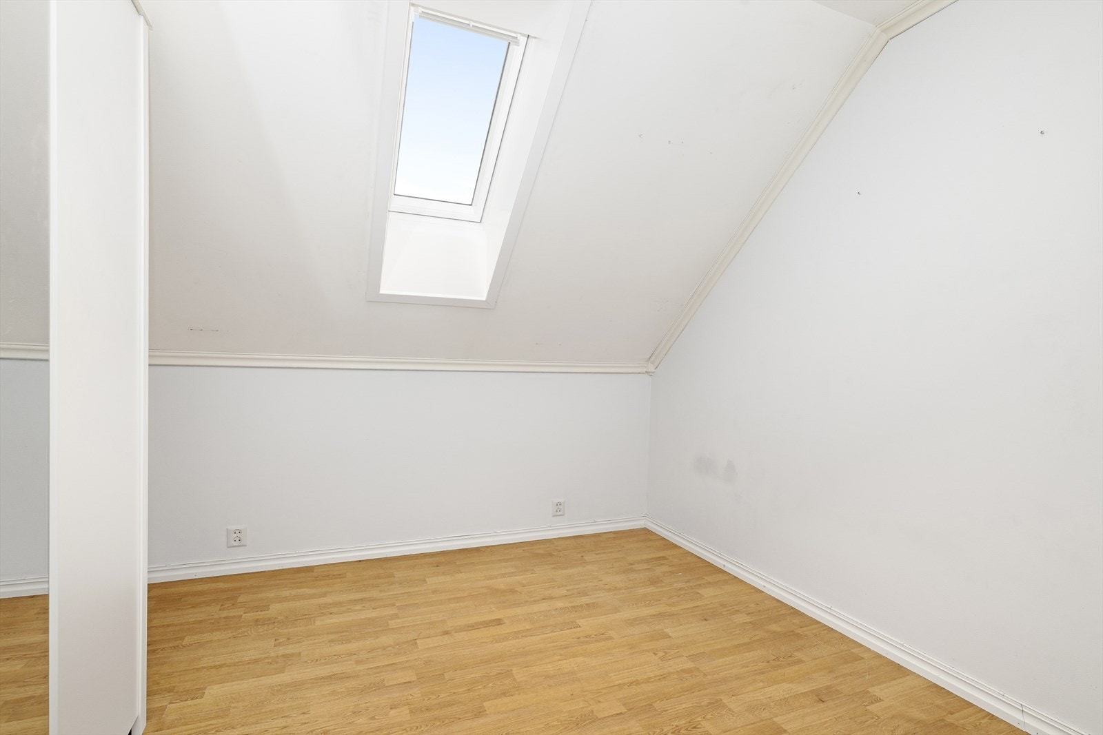 Leilighetens soverom har også takvindu, og det er oppbevaringsplass i garderobeskap med speilfelt. Galleribilde