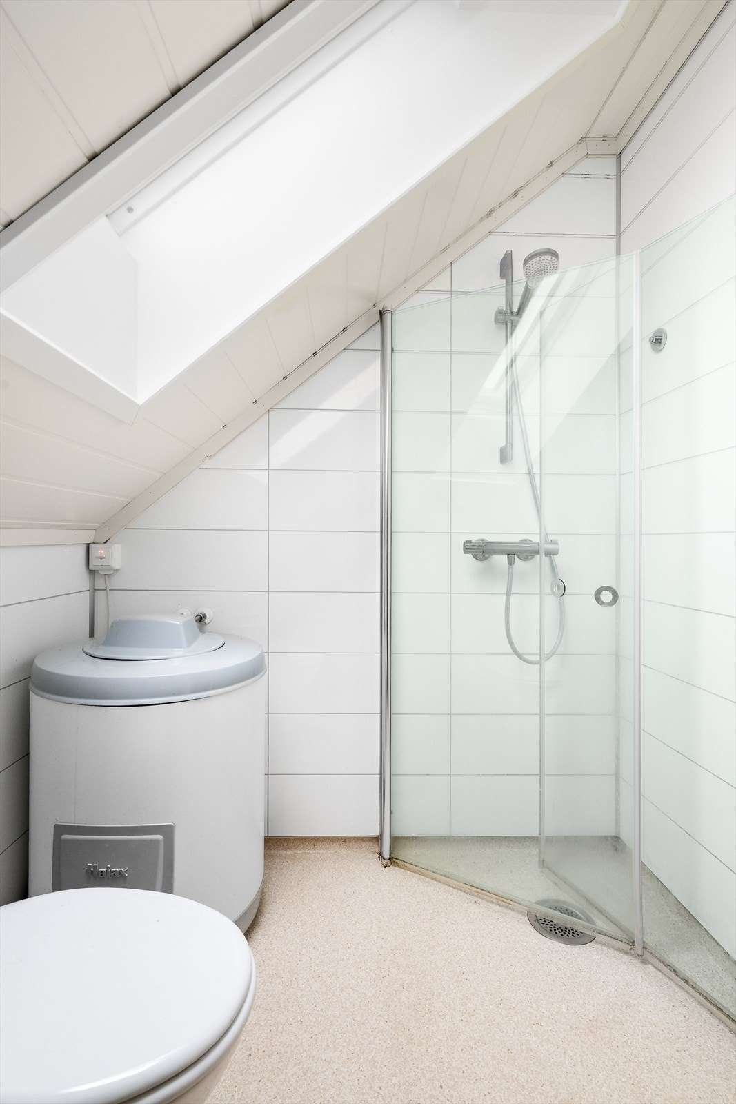 Badet er også innredet med dusjnisje med innfellbare glassvegger, toalett og varmtvannsbereder. Det er elektrisk styrt vifte. Galleribilde