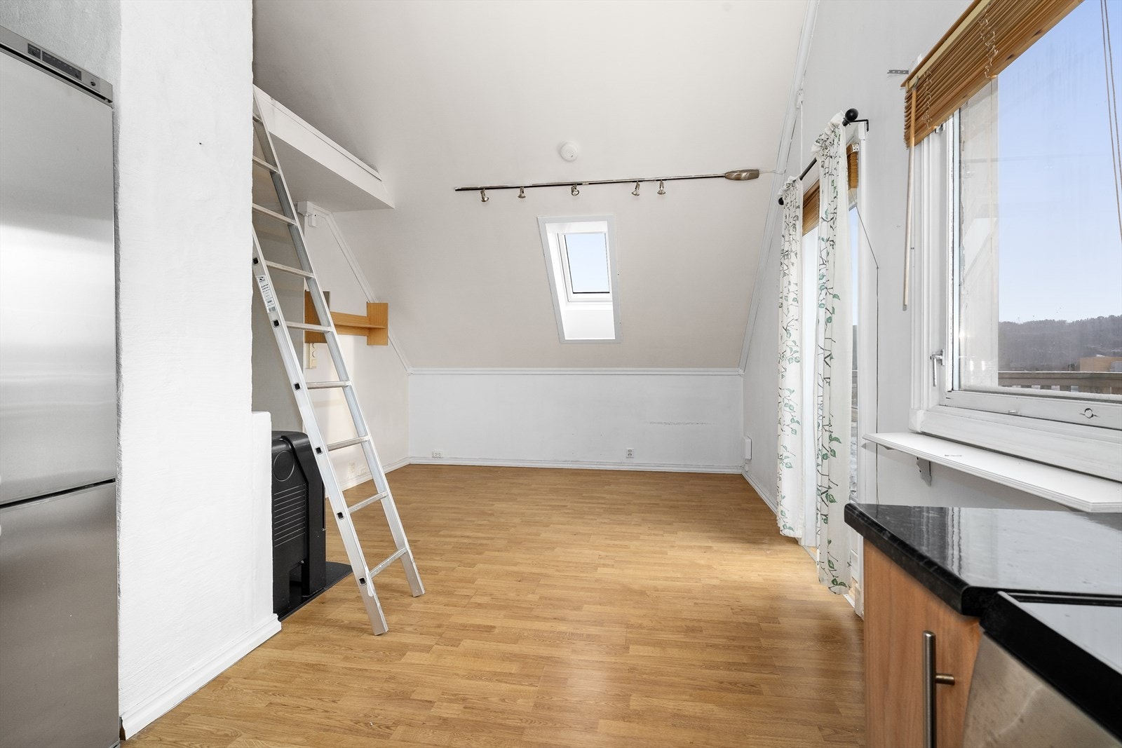 Stue og kjøkken i åpen løsning, med god takhøyde som gir en god romfølelse. Galleribilde